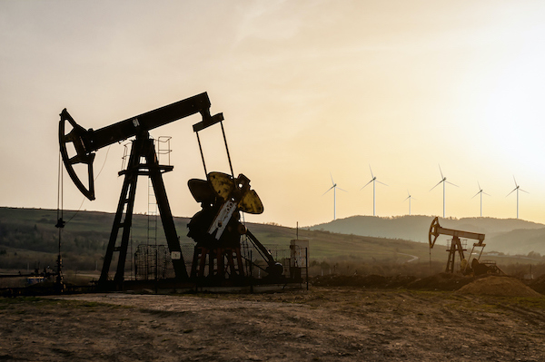 oil pumps and electric windmills at sunset